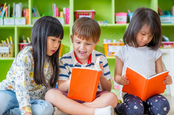 孩子们坐在地板<strong>上</strong>和阅读故事书在学龄前李