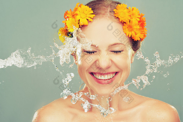美笑女孩溅起的水和黄色的花