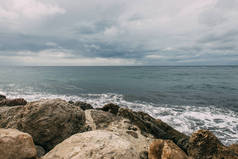 靠近岩石的地中海与乌云相映成趣 
