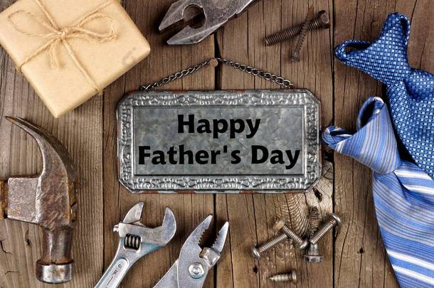 快乐的父亲节信息在金属标志与框架的工具, 礼品和领带在一个木制的背景下