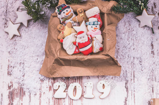 圣诞姜饼在一个盒子, 节日礼物和圣诞节装饰与雪的木背景与雪。圣诞快乐, 2019年新年快乐.