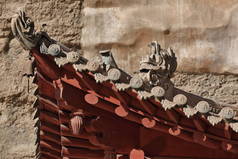 用龙形塑像在砖瓦屋顶上改建的屋檐- - 96-Mogao洞S区的9层楼高的木制门廊，有492个洞穴和4-14世纪的蜂窝庙宇。敦煌甘肃-中国.