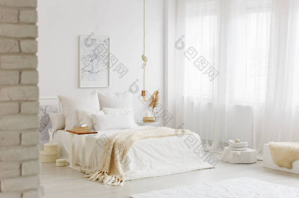 床与<strong>白色</strong>床上用品在宽敞的<strong>卧室</strong>内部与黄金装饰和大窗口