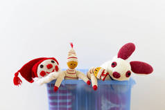可爱和有趣的老式儿童玩具在一个蓝色的塑料盒在白色的墙壁前。分类包括一个小丑, 兔子和木偶.