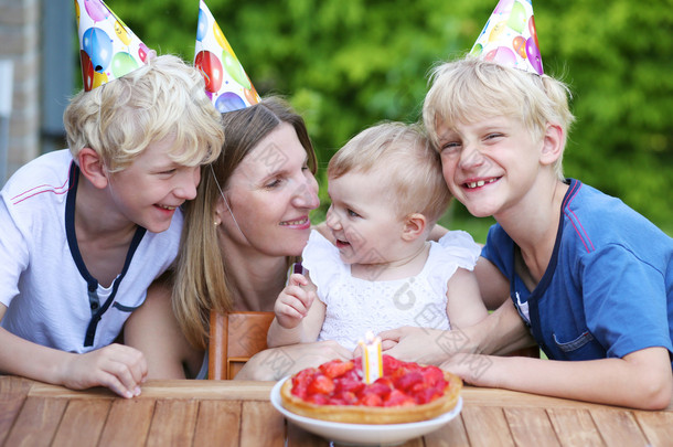 母亲和三个孩子玩得开心庆祝第一个生日