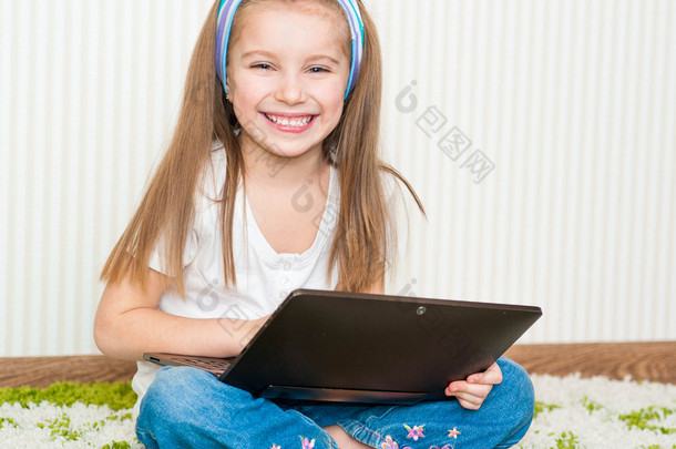 小女孩用一台笔记本电脑