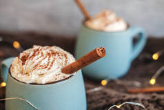 一杯咖啡、可可或热巧克力, 配上奶油和肉桂, 围巾上有叶子、花环、八角星。南瓜拿铁--寒冷的秋天或冬天的舒适饮料.