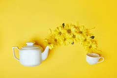 黄色菊花从白壶倒入杯中
