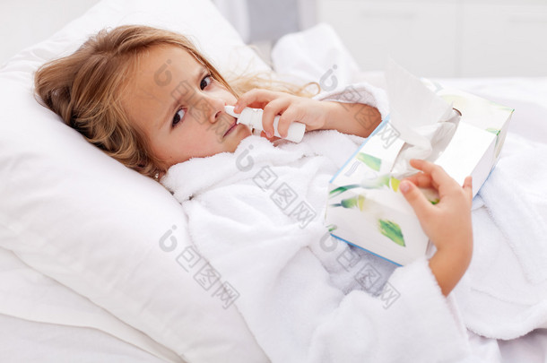 重感冒-使用喷鼻剂和纸餐巾的小女孩