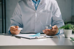 医生坐在办公桌前，手持听诊器靠近蓝色感知带的剪影