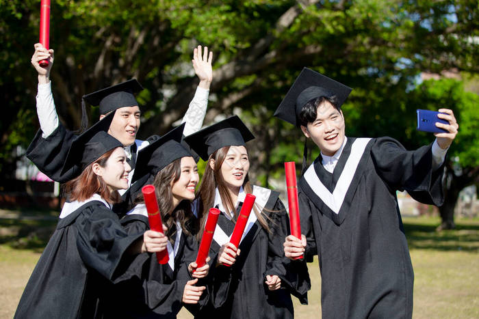 一群快乐的毕业生学生们用手机把学生们拉到图片-包图网企业站