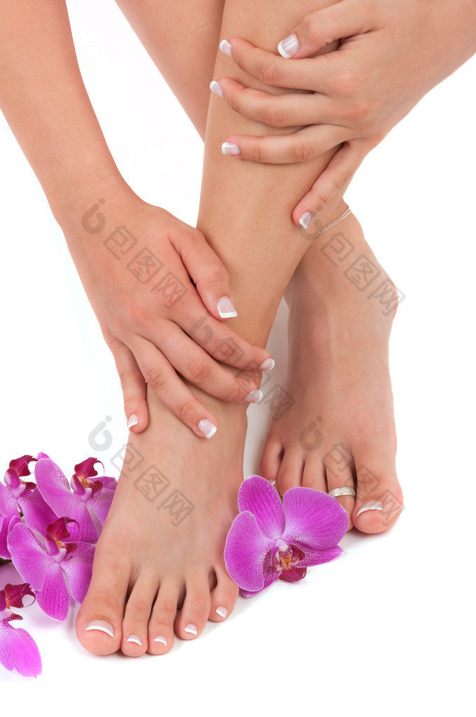 pedicured 的脚、 修剪整齐的手和兰花