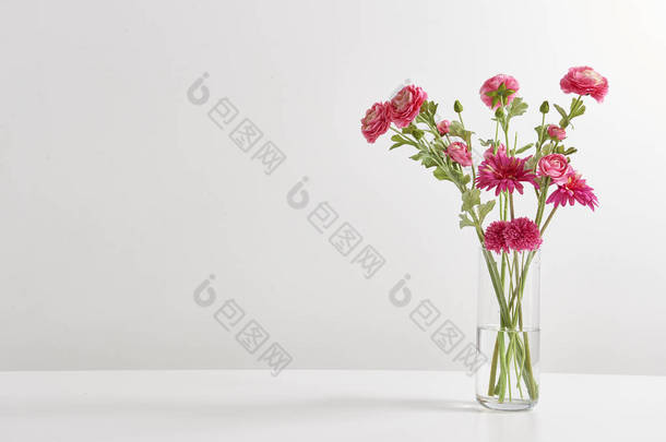 白色壁纸后面的花瓶中的花