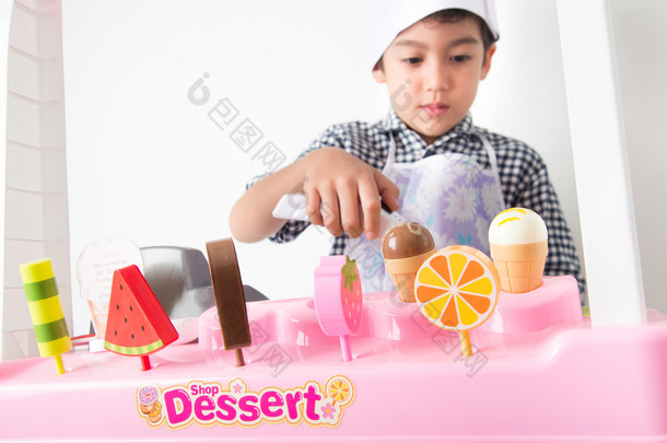 小男孩玩假装作为卖方在冰淇淋店