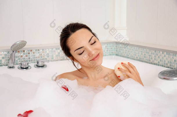 漂亮的女人在浴缸里放松