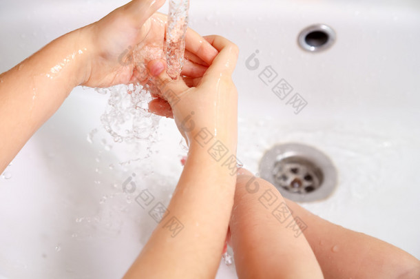儿童在自来水下的白色<strong>水槽</strong>洗手
