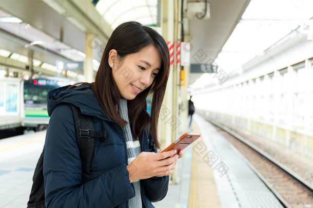 女<strong>人</strong>在火车平台使用<strong>手机</strong>