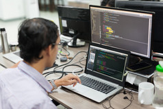 亚洲外包软件开发人员看屏幕坐在办公桌前
