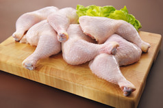 新鲜原料鸡的腿安排的厨房切菜板