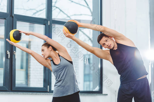 运动的年轻夫妇举行球和训练一起在<strong>健身</strong>房