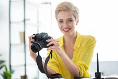 女摄影师在 photostudio 桌上手持相机的画像 