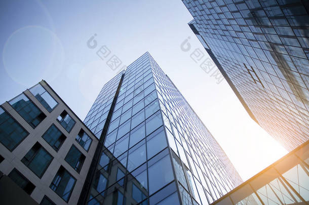 摩天大楼，现代建筑在<strong>城市</strong>与阳光。办公大楼在阳光下的玻璃墙。办公大楼窗户因日出、倒影和透视而关闭.