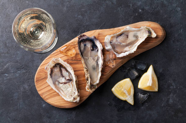 牡蛎在切菜板和白葡萄酒