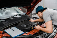 汽车机械师与万用表电压表检查汽车电池电压在机械车间