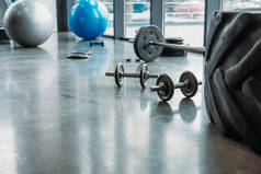 杠铃, 哑铃, 健身球和训练轮胎在地板上的健身房