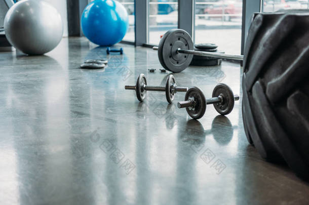 杠铃, 哑铃, 健身球和训练轮胎在地板上的健身房