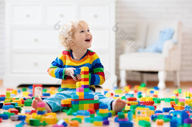孩子们玩五颜六色的玩具块.小男孩在家里或托儿所建塔。幼儿教育玩具。婴儿或幼儿的建筑块。幼稚园<strong>游戏</strong>室的烂摊子.