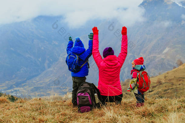 幸福的母亲和两个孩子在冬天山旅行