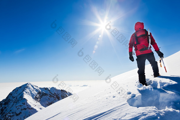 <strong>登山运动员</strong>到达顶部的雪山在阳光明媚的冬天