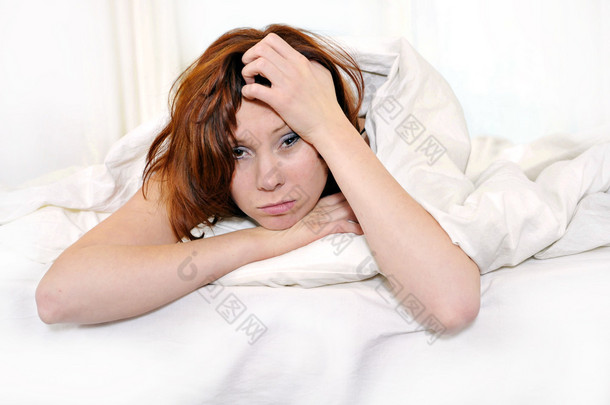 红头发的女人在床上醒来头痛与宿醉