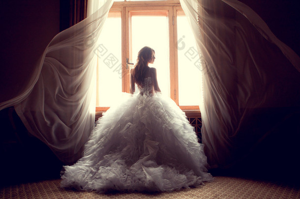 美丽的新娘对在室内的窗口