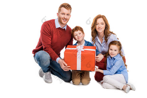 快乐红发家庭持有<strong>大礼</strong>品盒和微笑在相机上孤立的白色