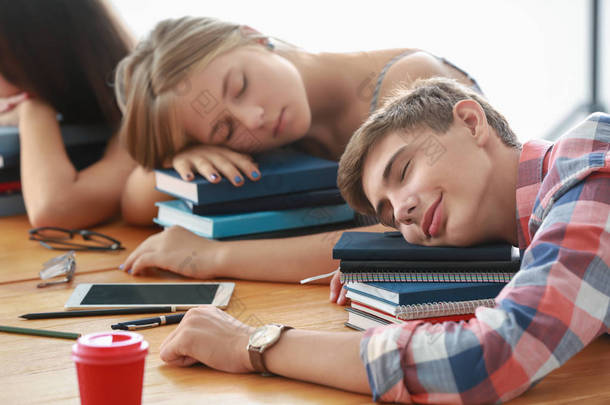 疲倦的学生睡觉在桌