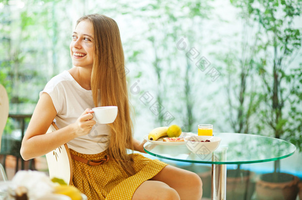 年轻漂亮的女人吃早餐 (软焦点)