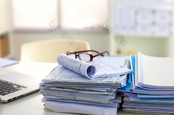 堆文件和眼镜躺在降低饱和度的表