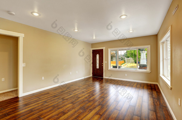 空房子的内部。宽敞的客厅与新的硬木地板
