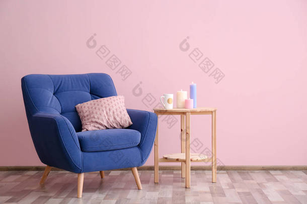 软扶手椅和边桌在颜色墙壁附近