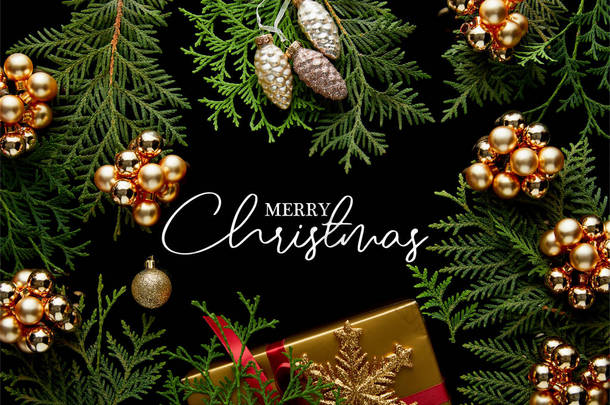 金光闪闪的圣诞装饰，绿色的thuja树枝和礼品盒的顶视图，用快乐的圣诞图解与黑色隔开
