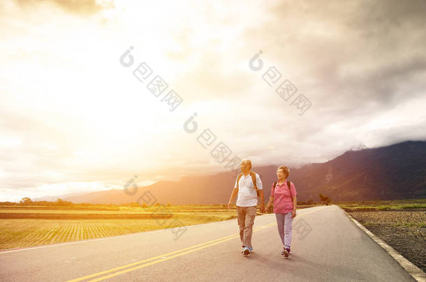 年长的夫妇在乡村小路上徒步旅行