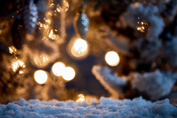 在雪地里用圣诞球和夜晚的灯把云杉树枝紧紧地粘在一起  