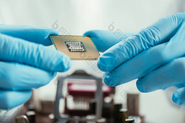 橡胶手套中的工程师手持计算机微晶片的剪影