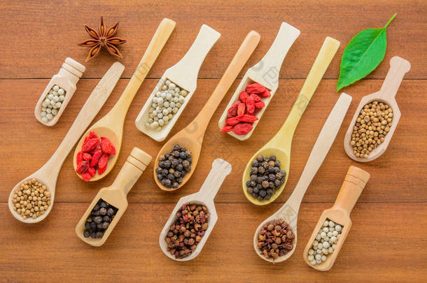 各种干草药 (干粒) 在木勺上, 不同种类的干草药在木勺空间上放在木桌上。健康营养食品概念.