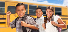 年轻的西班牙裔男孩和女孩走在校车附近.