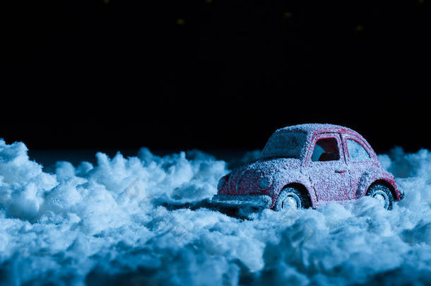 在夜间站在雪地里的微型汽车的特写镜头