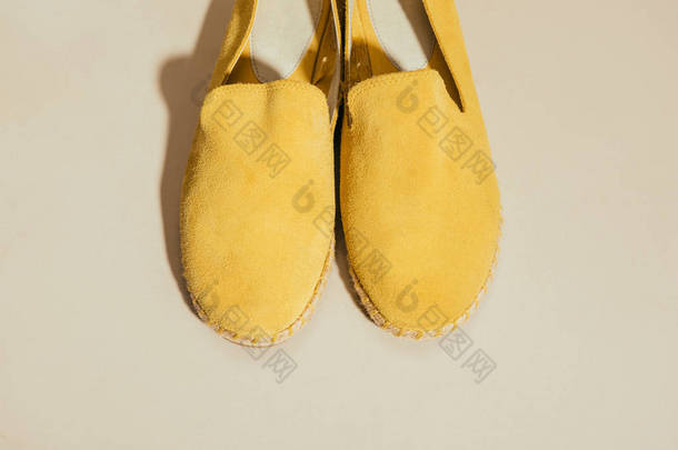 黄色时尚帆布鞋在米色背景上的特写视图