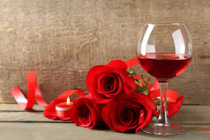 红酒在眼镜、 红玫瑰和木制背景装饰心组成